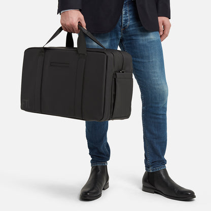 Gym and office bag in black with structured silhouette and side pocket, ideal for business attire and workout gear.